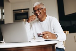 An older man researches online banks.