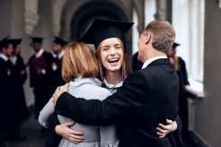 Proud cosigners hug student at college graduation